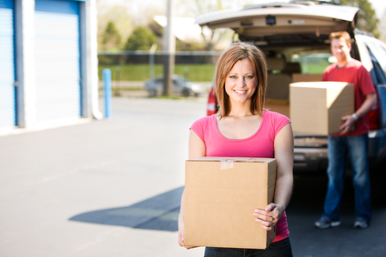 Couple moving boxes from vehicle.