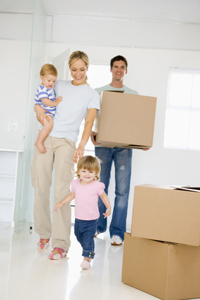 Family with box moving into new home smiling